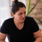 A woman enjoys a moment of relaxation with coffee in a cozy cafe setting.